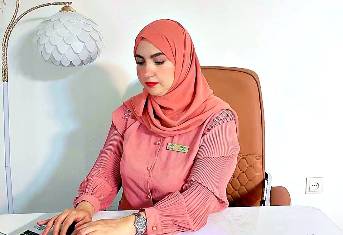 الكوتش دنيا تعمل على حاسوبها في مكتب الأكاديمية